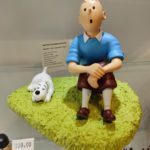Tintin assis dans l'herbe